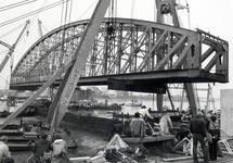 170368 Afbeelding van het uithijsen van de oude overspanning van de spoorbrug over de Waal te Nijmegen, tijdens de ...